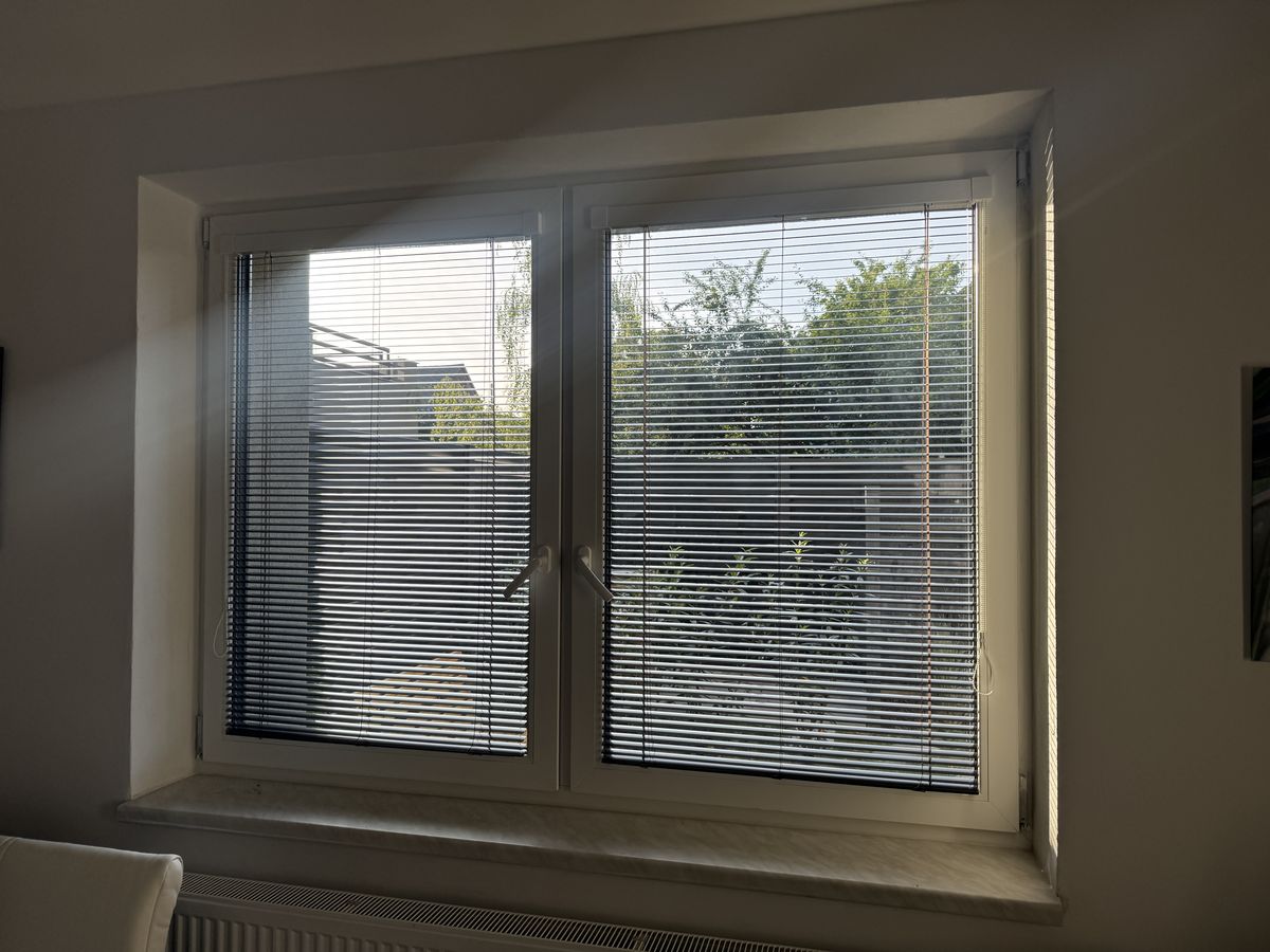 Horizontální žaluzie v okně obývacího pokoje