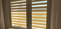 Žluté rolety den a noc v okně a na balkonových dveřích